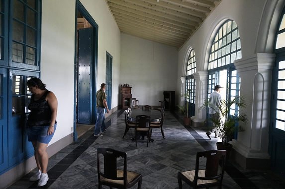 tourists in museum hall with colonial furniture