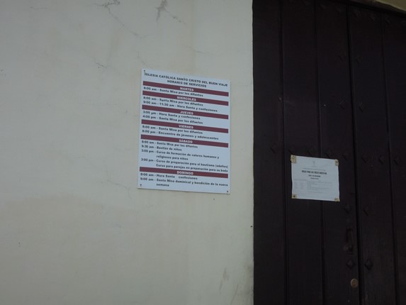 sign with schedules on the door of the church