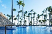Gran piscina exterior con palmeras y bar swim-up