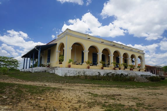 hacienda colonial amarilla rodeada de vegetación