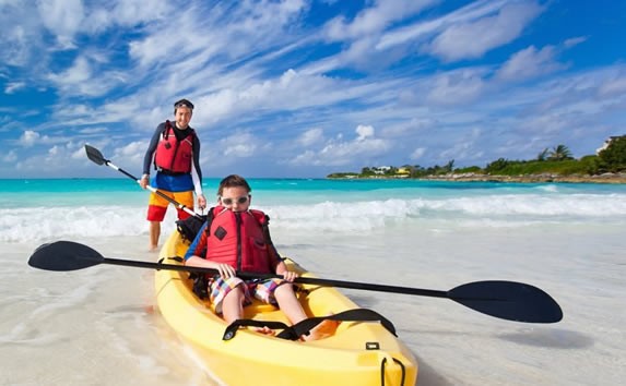 children on yellow kayak on the shore of the beach