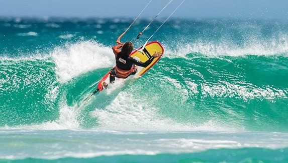 tourist surfing in the blue sea