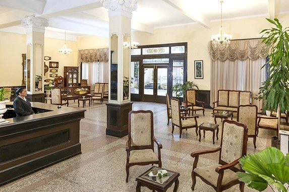 lobby con mobiliario antiguo y recepción de madera