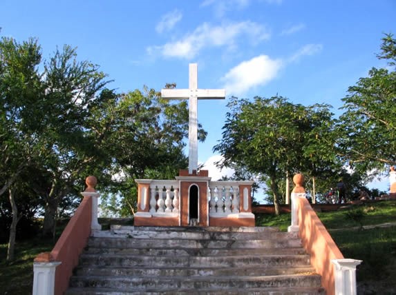 cross on an outdoor altar surrounded by trees