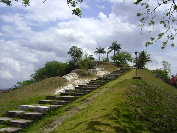 loma verde con escaleras de piedra y vegetación