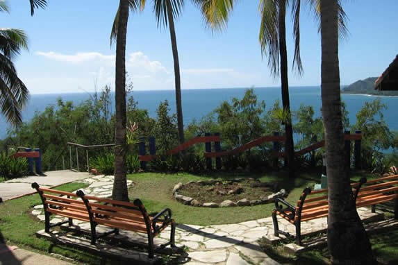 jardín frente al mar con bancos de madera