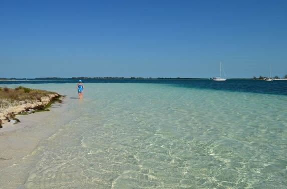 turista en la playa de aguas azules y arena blanca