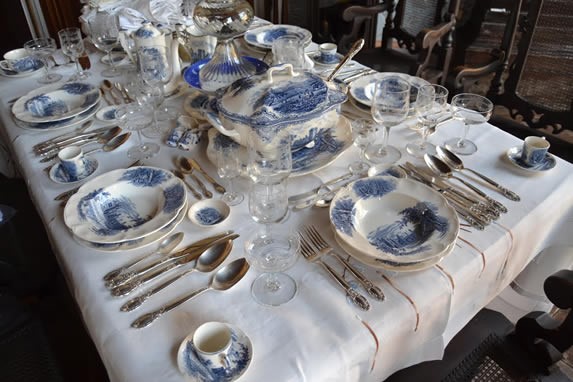 Table with crockery and antique cutlery.