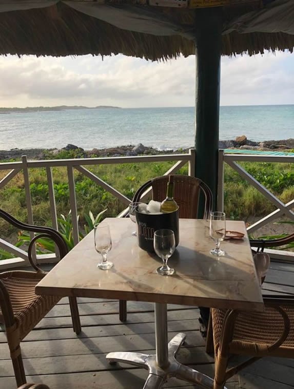 table under guano roof with sea view