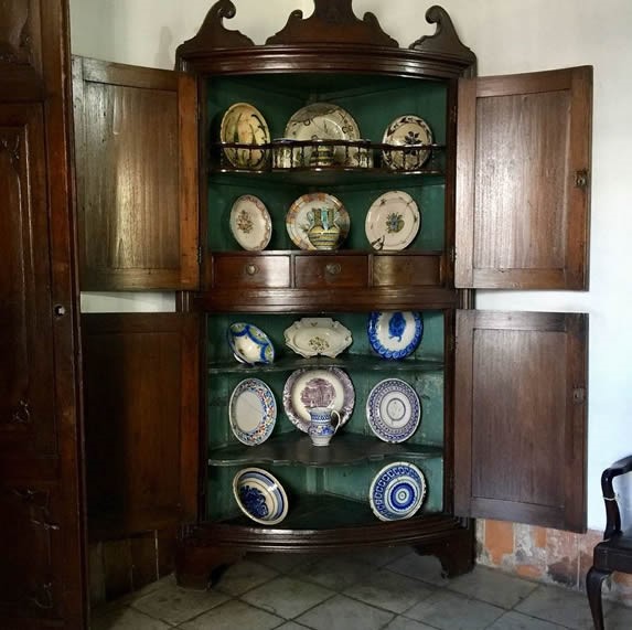 antiguo mueble de madera con objetos de porcelana