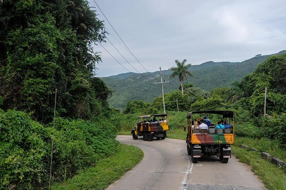 Rustic trucks with tourists on a road