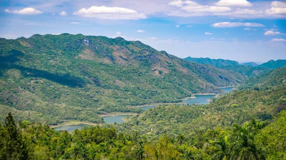 paisaje de montañas con vegetación junto a río 