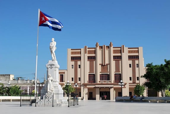 monumento de mármol junto a la bandera cubana 