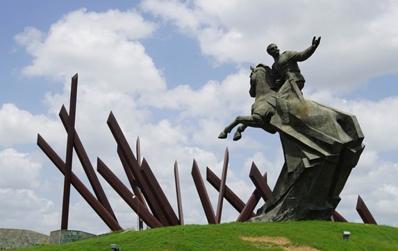 bronze sculpture on grass under blue sky