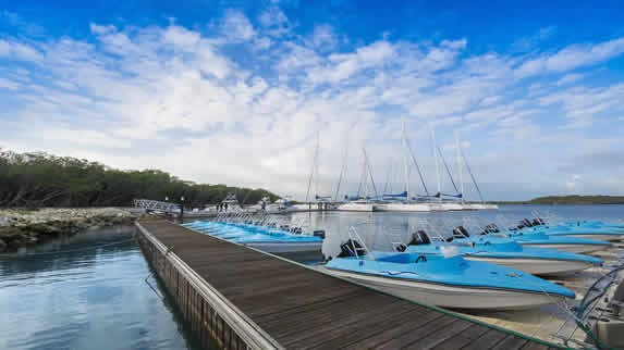 muelle de madera y pequeñas lanchas azules