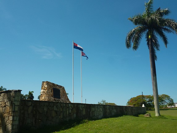 jardín con antiguo muro de piedras y bandera 