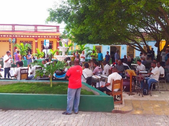 músicos tocando en el parque rodeado de vegetación