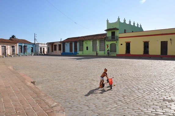 boy playing in the square surrounded by buildings