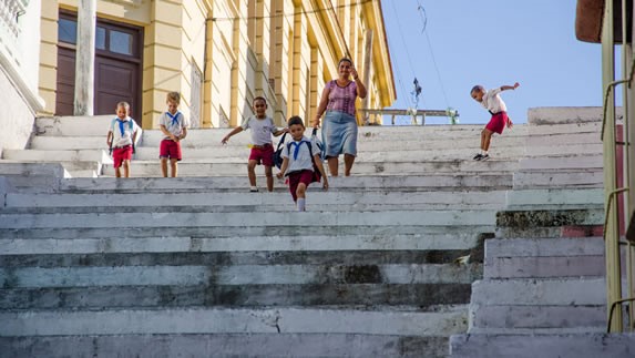 niños en uniforme bajando una gran escalera 