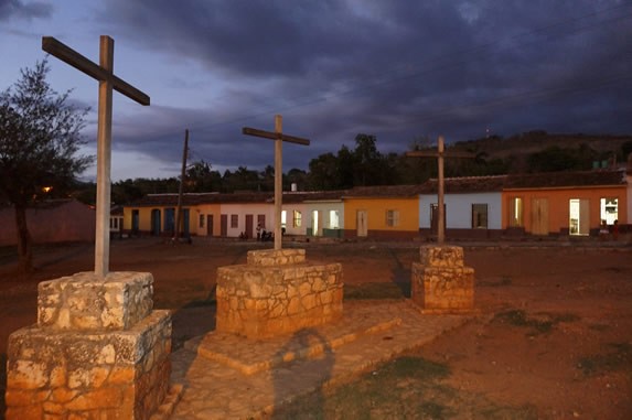 monument of three wooden crosses on the grass.