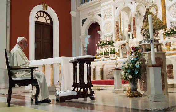 papa frente a altar con flores y figura religiosa