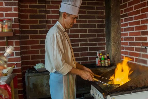 chef con uniforme cocinando en el grill