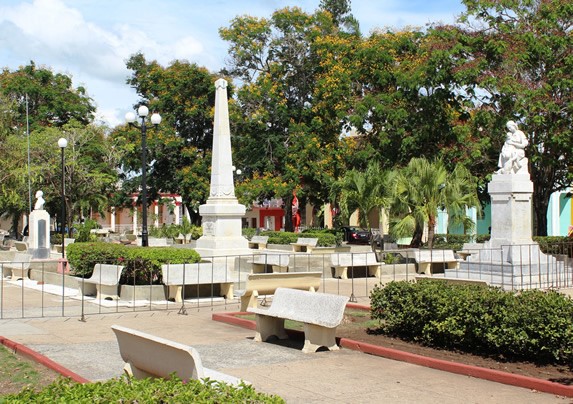 parque con esculturas cercadas y bancos 
