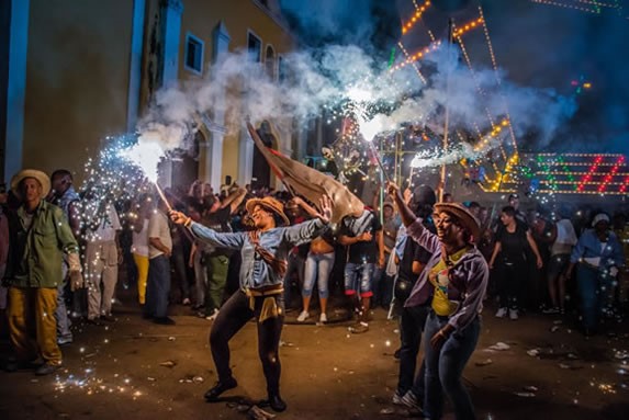 people dancing and holding flares