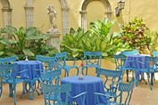 patio interior con sillas y mesas azules 