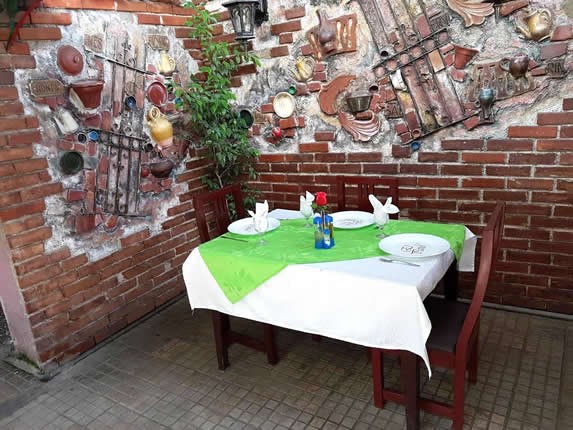 covered patio with furniture and greenery