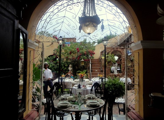 puerta de entrada el patio con mesas y vegetación