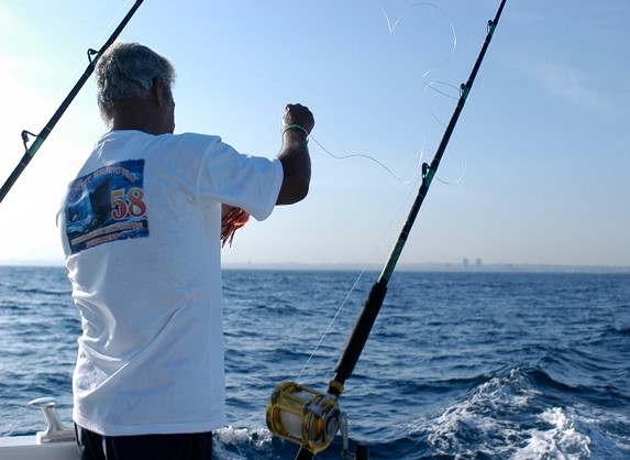 tourists holding fishing rods in the sea