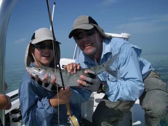 fishermen holding their rods and fresh fish