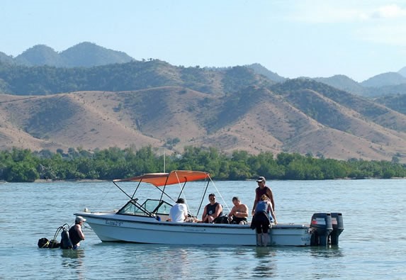 lancha de pescadores en la playa y montañas atrás