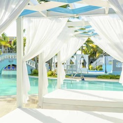 pool with sun loungers under white awnings