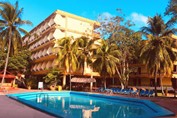 pool surrounded by sun loungers and palm trees