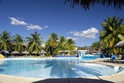 Hotel pool surrounded by palms and sun loungers