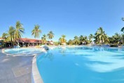 Pool surrounded by palm trees and sun loungers