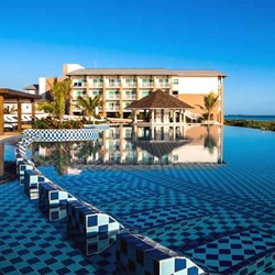 piscina junto al mar con palmeras alrededor