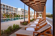 pool surrounded by white sun loungers indoors