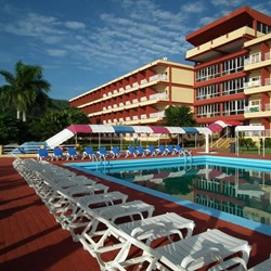 vista de la piscina rodeada de tumbonas azules