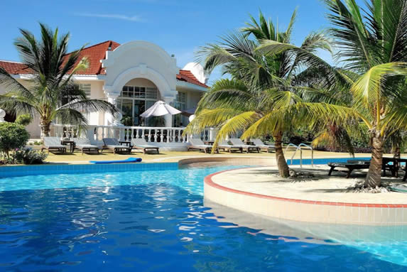 piscina rodeada de palmeras y tumbonas