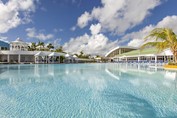 piscina con palmeras y tumbonas alrededor