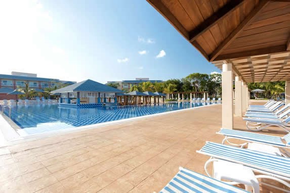 pool with loungers and palm trees around