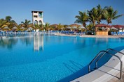 piscina con tumbonas y palmeras alrededor