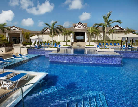piscina con palmeras y tumbonas alrededor