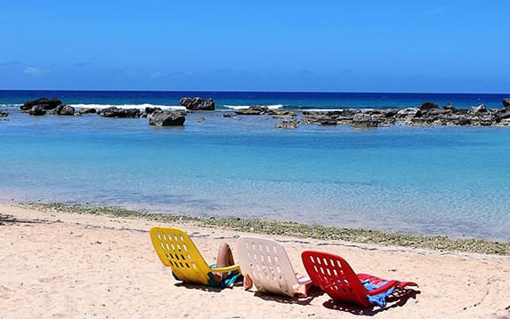 colorful sun loungers on white sand beach