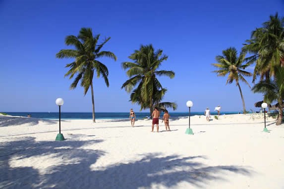 Tourists on the beach of golden sands and palms