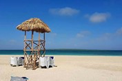 playa con tumbonas azules y puesto salvavidas