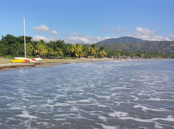 beach with kayaks and mountains in the background